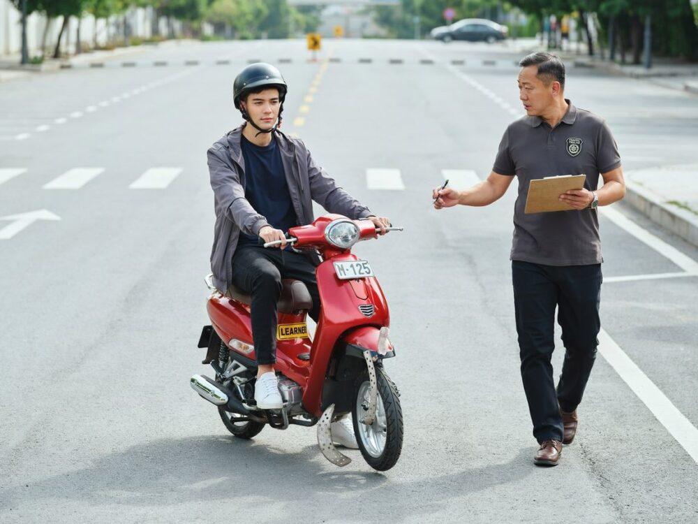 instruktor obserwujący egzamin na kartę motorowerową